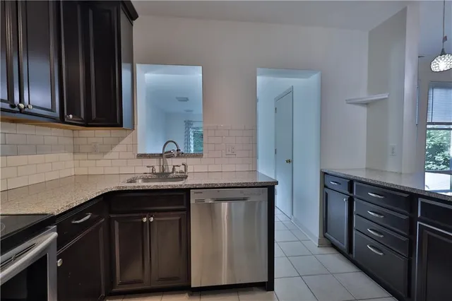 a view of a kitchen with a sink and an empty room