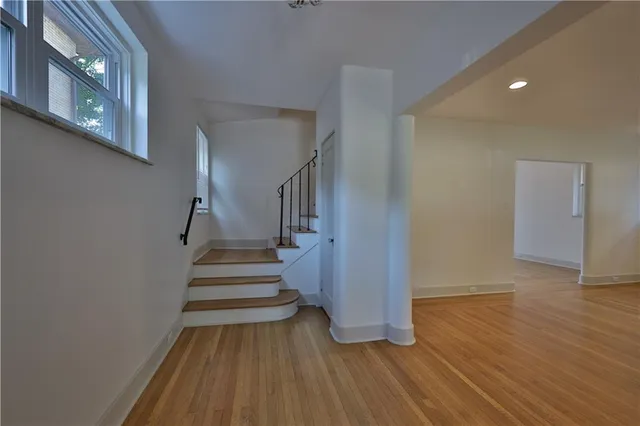a view of a hallway with wooden floor and staircase