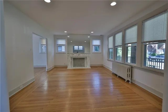 an empty room with wooden floor and a fireplace
