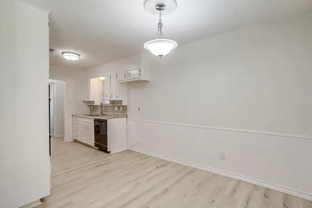 a kitchen with cabinets wooden floor and a sink