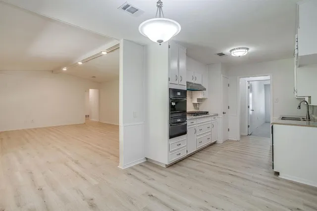 a kitchen with stainless steel appliances a stove refrigerator and cabinets