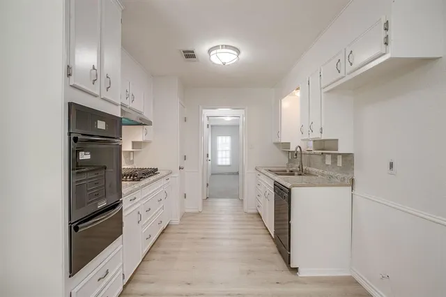 a large kitchen with stainless steel appliances granite countertop a stove and a sink