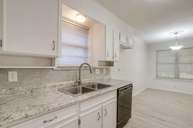 a kitchen with stainless steel appliances granite countertop a sink a stove and wooden cabinets