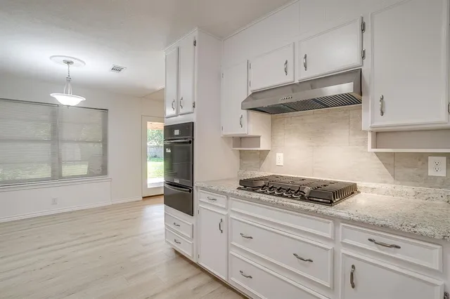 a kitchen with white cabinets and appliances