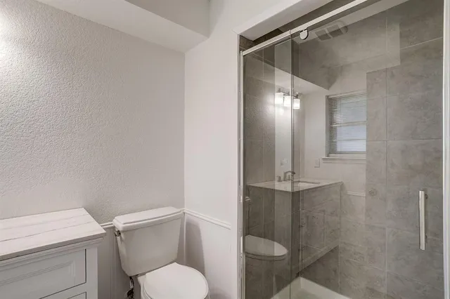 a white toilet sitting next to a shower