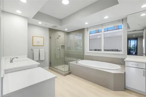 a bathroom with a bathtub a mirror a double vanity sink and