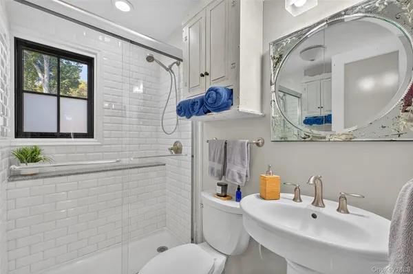 a bathroom with a sink a toilet and mirror