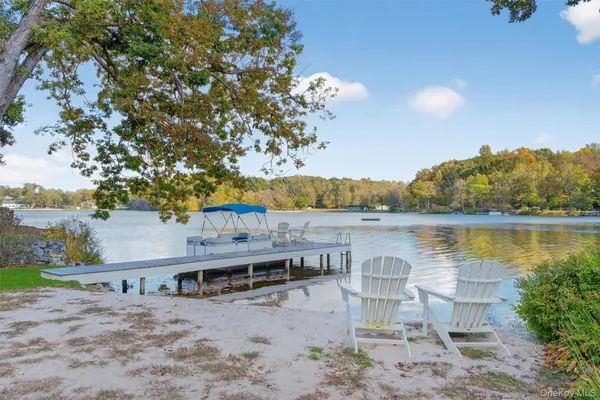 a view of a lake with lawn chairs