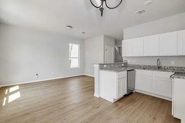 a kitchen with granite countertop white cabinets and white appliances