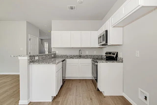 a kitchen with stainless steel appliances granite countertop a stove and a refrigerator