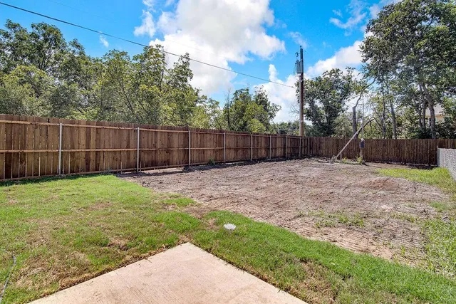 a view of a backyard with a fence and plants