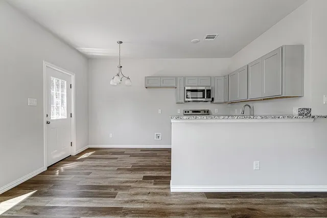 a view of kitchen with granite countertop cabinets and wooden floor
