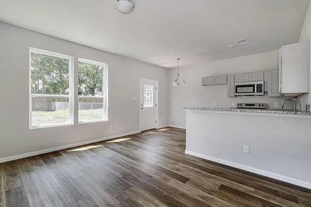 a view of kitchen with granite countertop cabinets and wooden floor