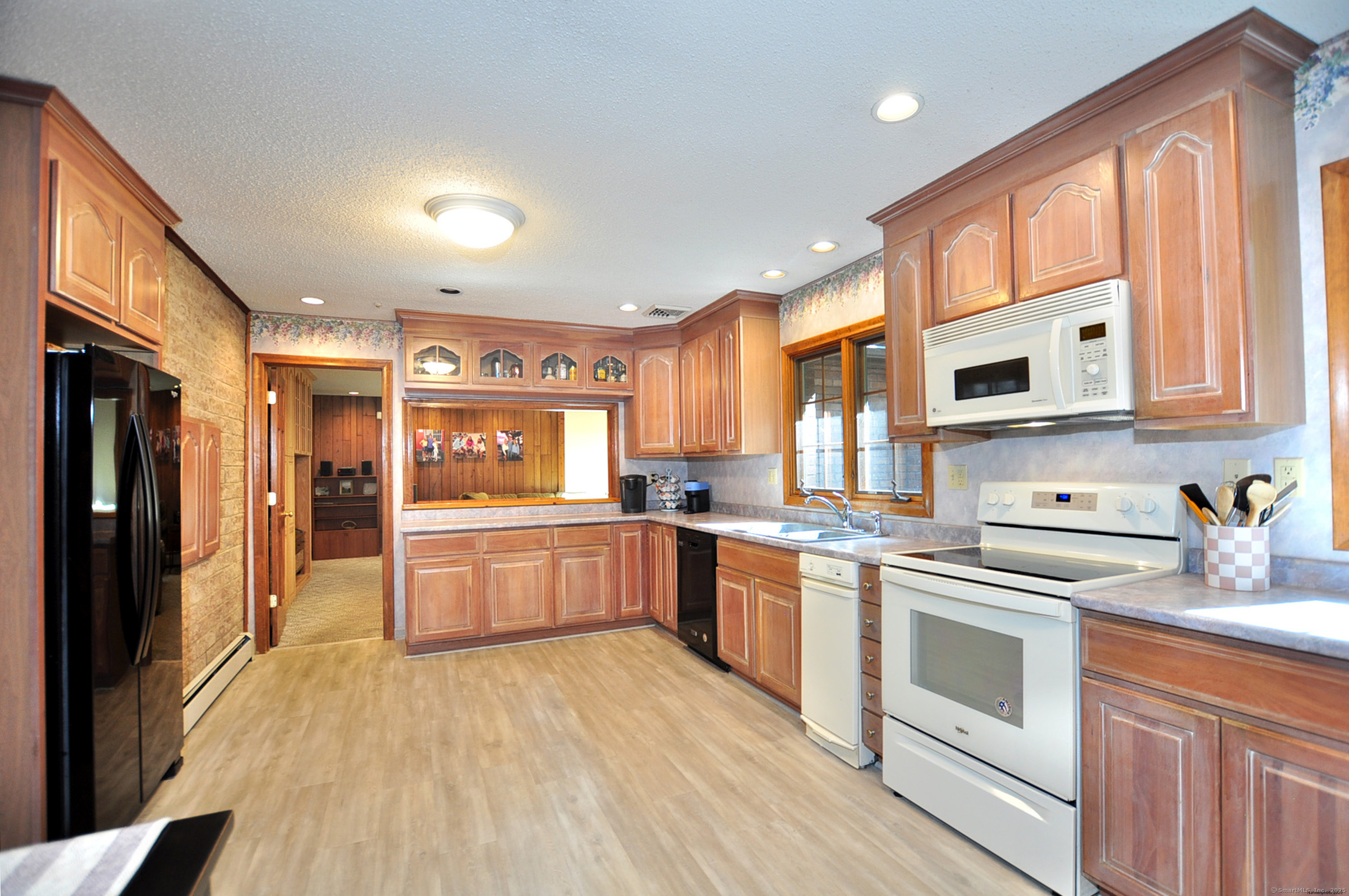 18 Fiano Road Bolton, CT 06043 - Photo 16 of 38 a kitchen with stainless steel appliances granite countertop a stove top oven a sink dishwasher a refrigerator and a dining table with wooden floor
