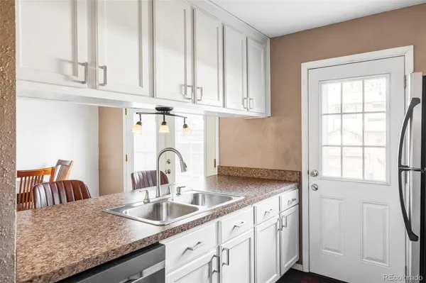 a kitchen with granite countertop a sink and cabinets