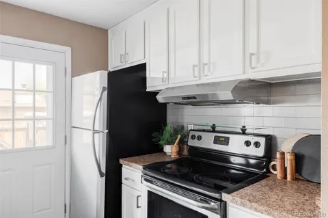a kitchen with stainless steel appliances granite countertop white cabinets and refrigerator