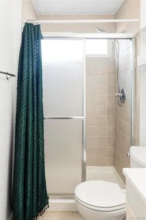 a bathroom with a toilet and a shower curtain