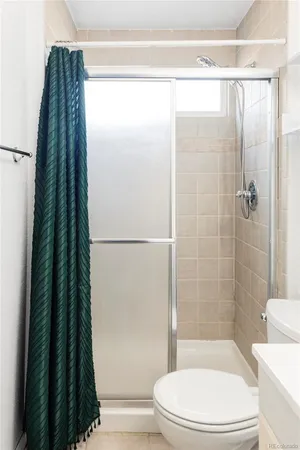a bathroom with a toilet and a shower curtain