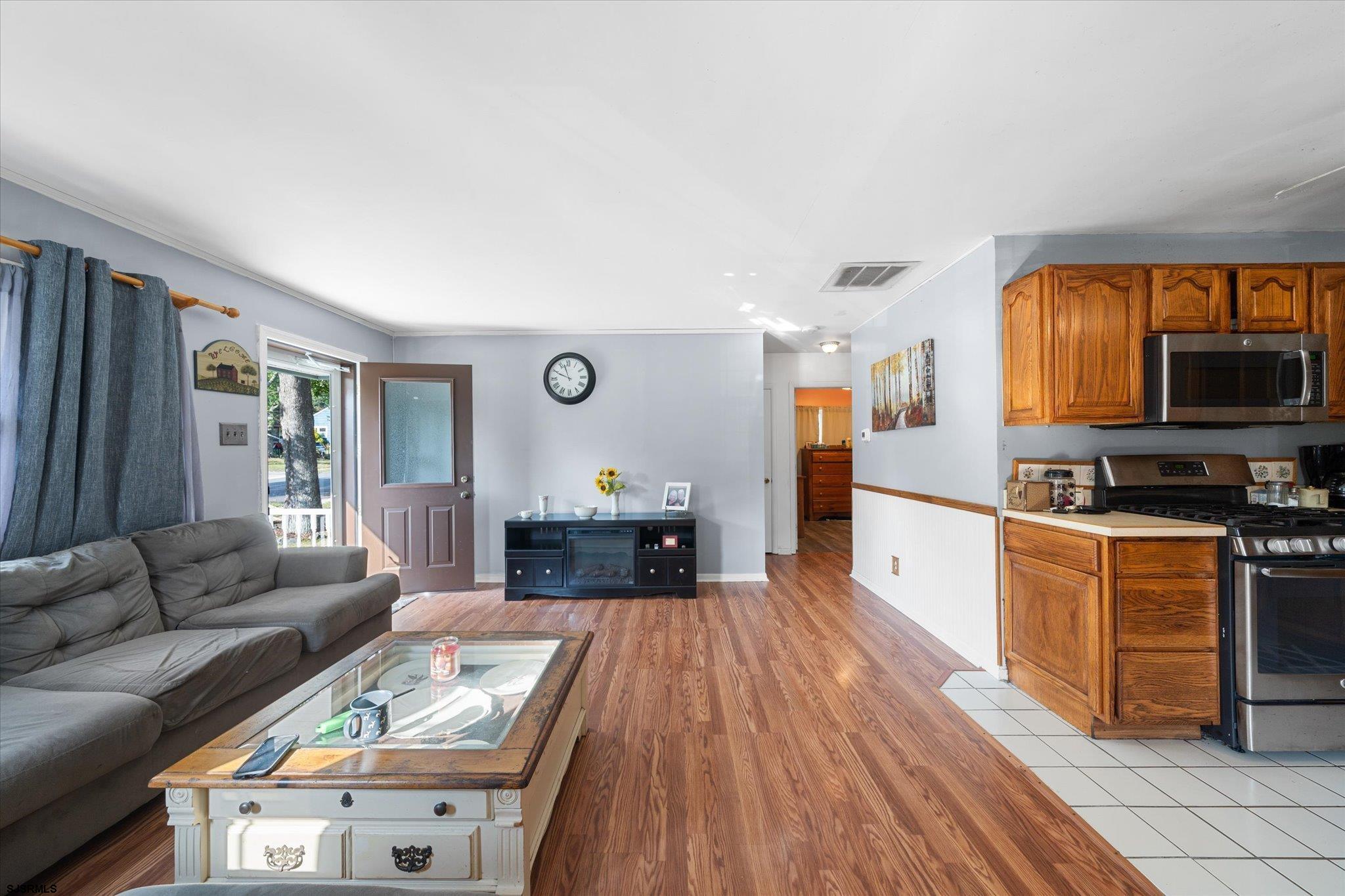 308 Pine Street Absecon, NJ 08201 - Photo 9 of 35 a living room with stainless steel appliances furniture a fireplace a flat screen tv and a window
