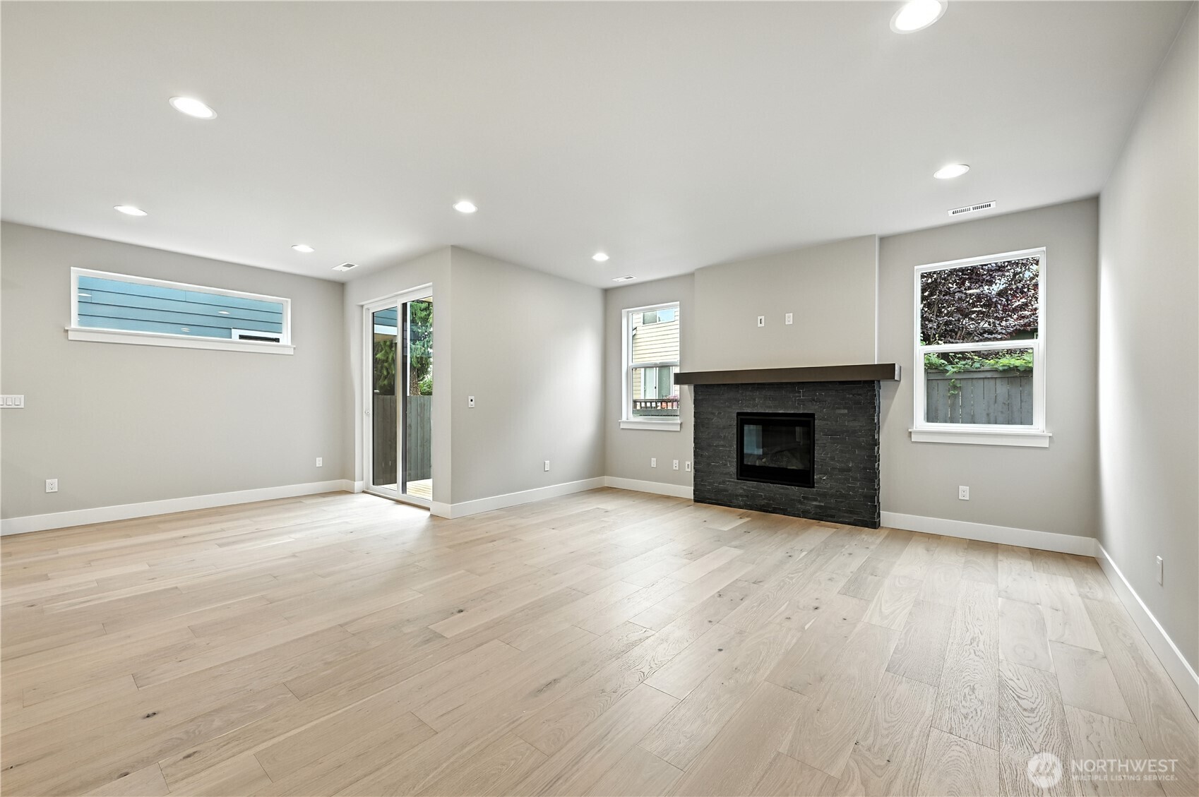 19225 Meridian Drive Southeast, Unit CW 15 Bothell, WA 98012 - Photo 10 of 31 an empty room with wooden floor fireplace and windows