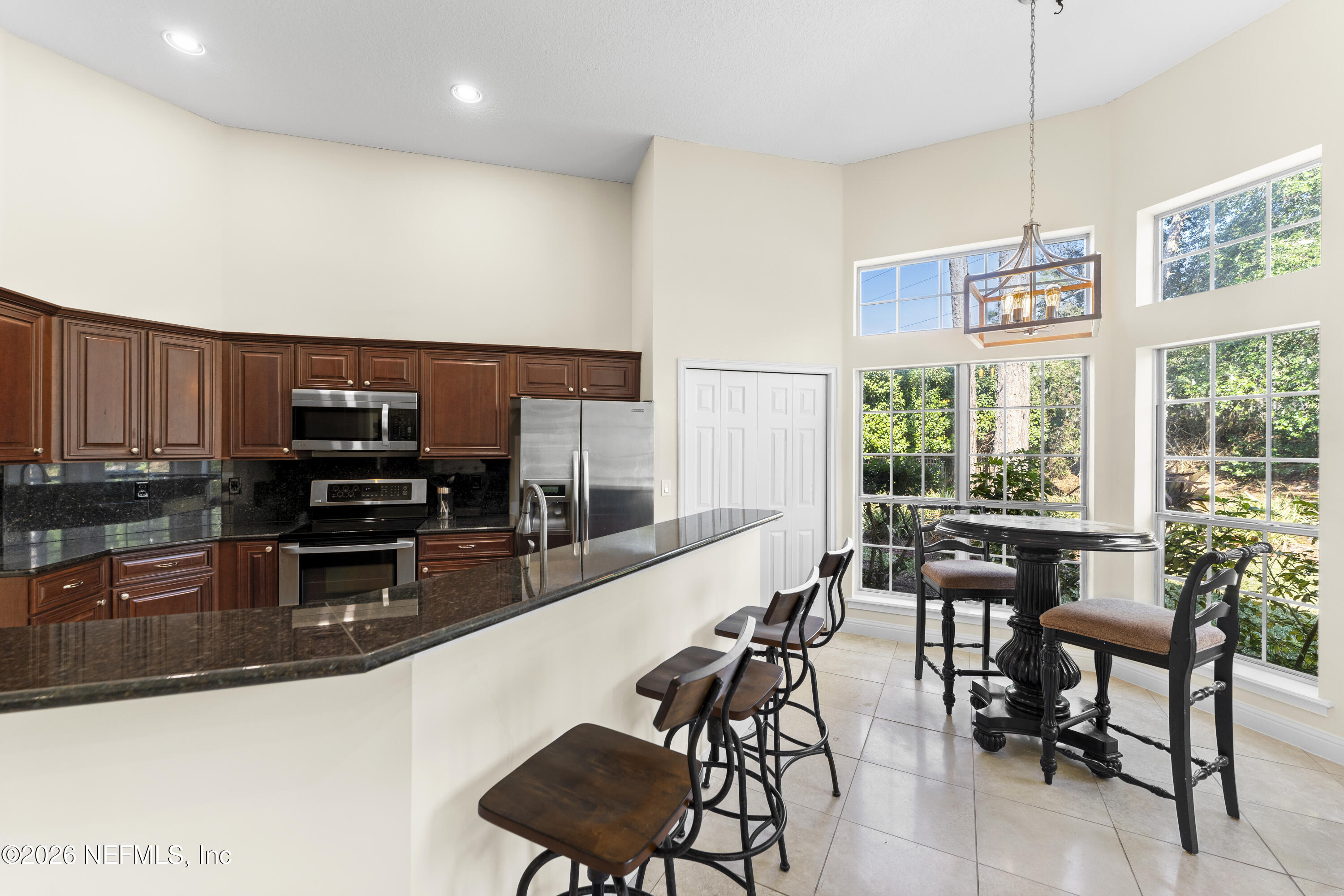 9957 Chelsea Lake Road Jacksonville, FL 32256 - Photo 18 of 73 a kitchen with stainless steel appliances kitchen island granite countertop a stove a sink a dining table and chairs