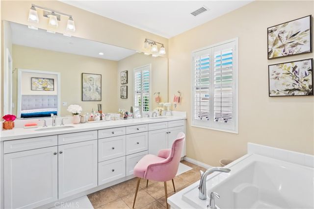 a spacious bathroom with double vanity sinks a mirror and a shower