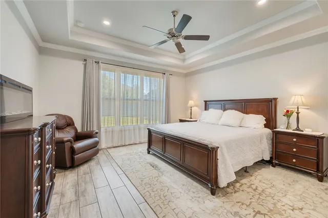 a bedroom with a bed couches and a flat tv screen