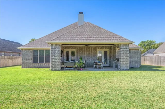 a view of a house with a yard and sitting area
