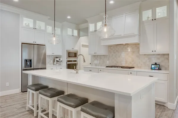 a kitchen with stainless steel appliances a stove a sink and a refrigerator