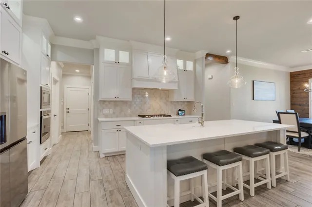 a kitchen with a dining table chairs appliances and cabinets