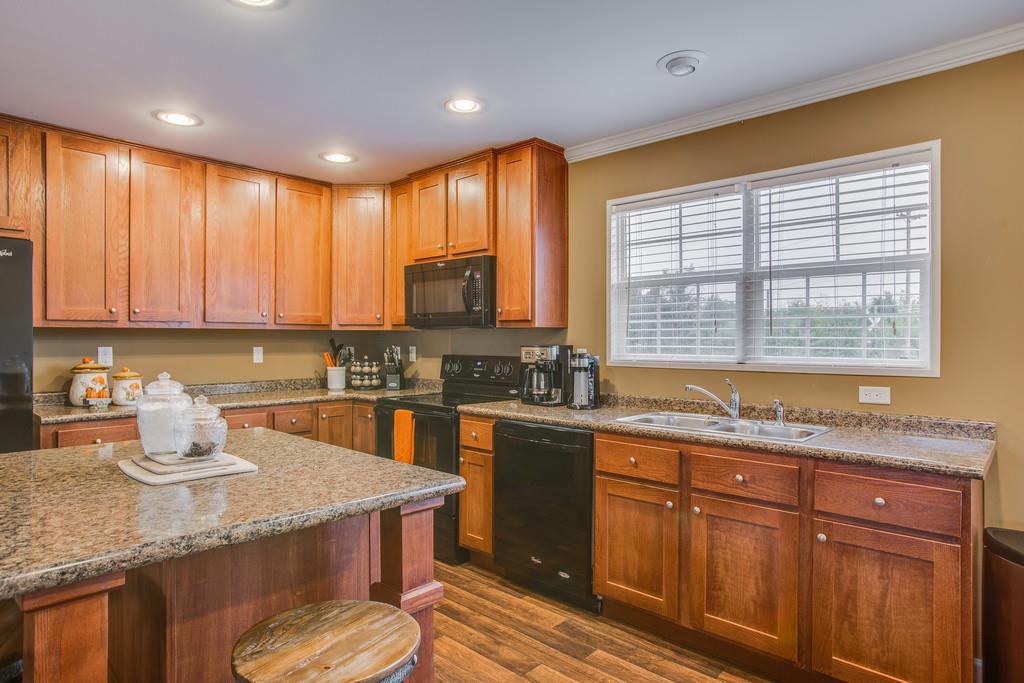 1142 Wrights Mill Road Spring Hill, TN 37174 - Photo 11 of 30 a kitchen with stainless steel appliances granite countertop wooden cabinets a sink and dishwasher with wooden floor