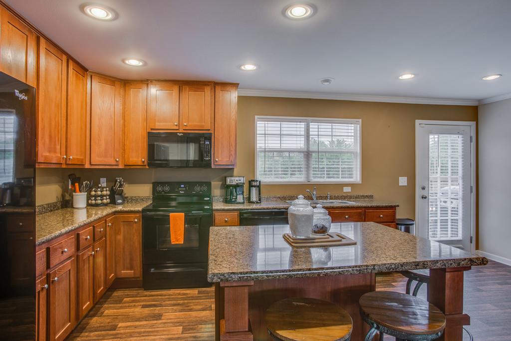 1142 Wrights Mill Road Spring Hill, TN 37174 - Photo 10 of 30 a kitchen with kitchen island granite countertop wooden cabinets and a refrigerator