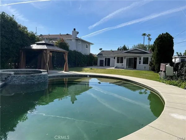 a view of a house with swimming pool and a yard