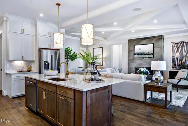 a kitchen with kitchen island granite countertop a sink cabinets and stainless steel appliances