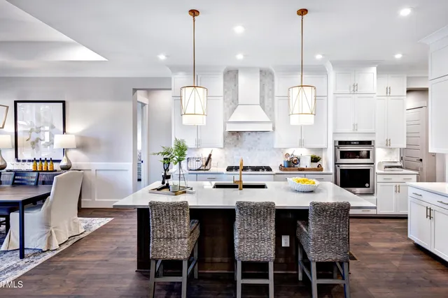 a kitchen with kitchen island granite countertop a sink a center island stainless steel appliances and cabinets