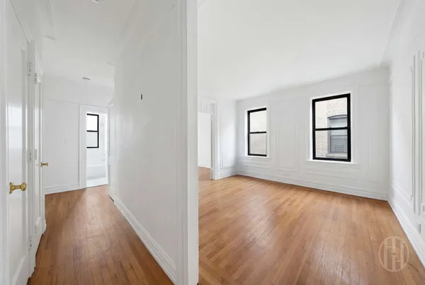 a view of a hallway with wooden floor and a window