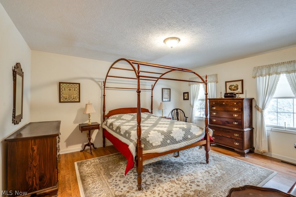 136 Taylor Road Barberton, OH 44203 - Photo 33 of 45 Bedroom featuring wood finished floors and a textured ceiling