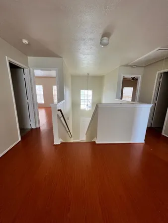 a view of a livingroom with wooden floor and furniture