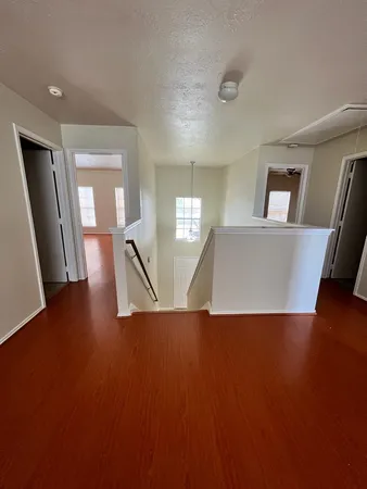 a view of a livingroom with wooden floor and stairs