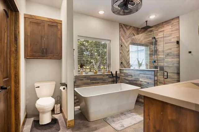 a bathroom with a bathtub a sink a toilet and a window