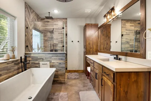 a bathroom with a double vanity sink a large mirror and a bathtub