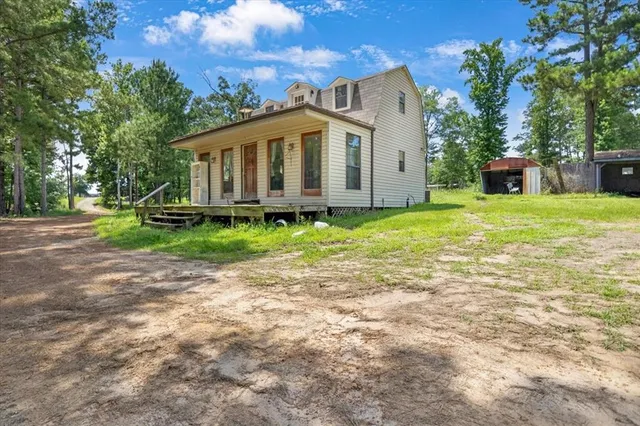 a view of a house with a yard and sitting area