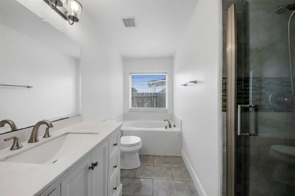 a bathroom with a granite countertop sink a toilet and shower