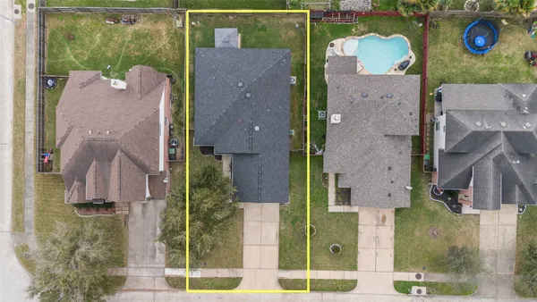an aerial view of residential houses with outdoor space and parking