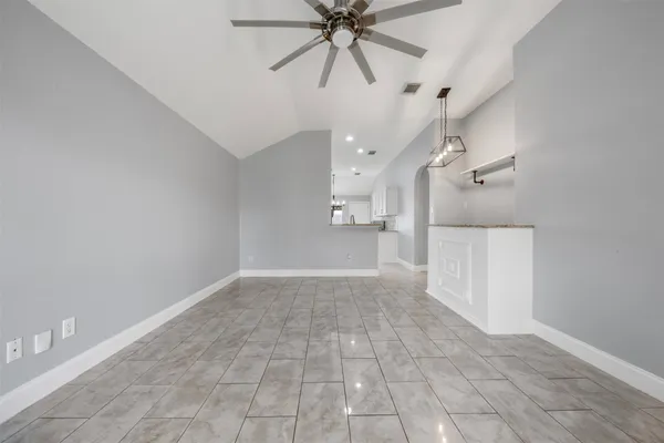 a view of a hallway with a chandelier fan and windows
