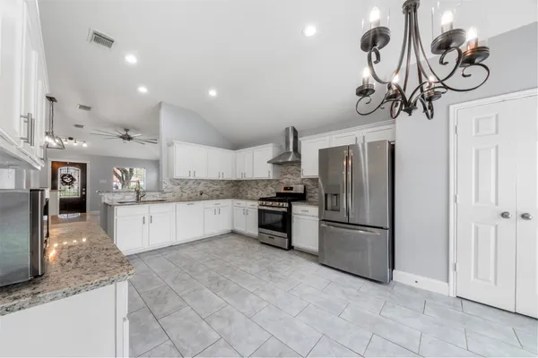 a kitchen with stainless steel appliances granite countertop a sink a refrigerator and a granite counter tops