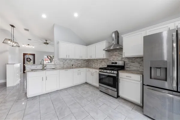 a kitchen with stainless steel appliances granite countertop a sink and a stove