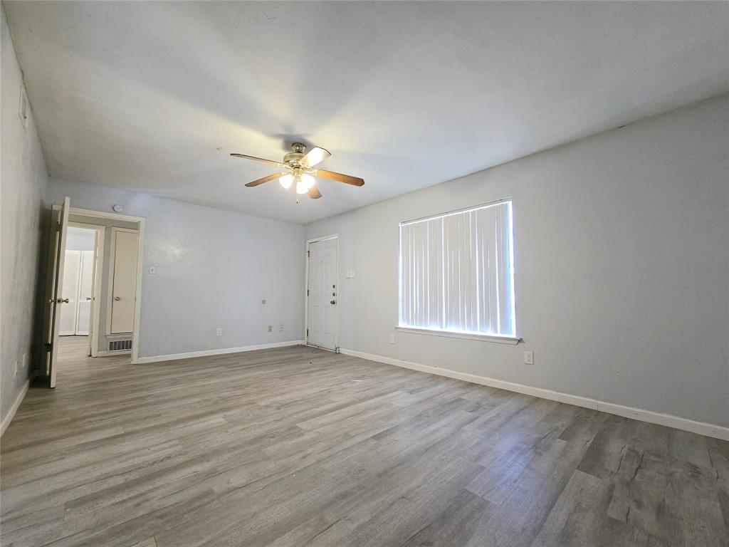 902 Spring Valley Plaza, Unit A Richardson, TX 75080 - Photo 4 of 11 wooden floor in an empty room with a window