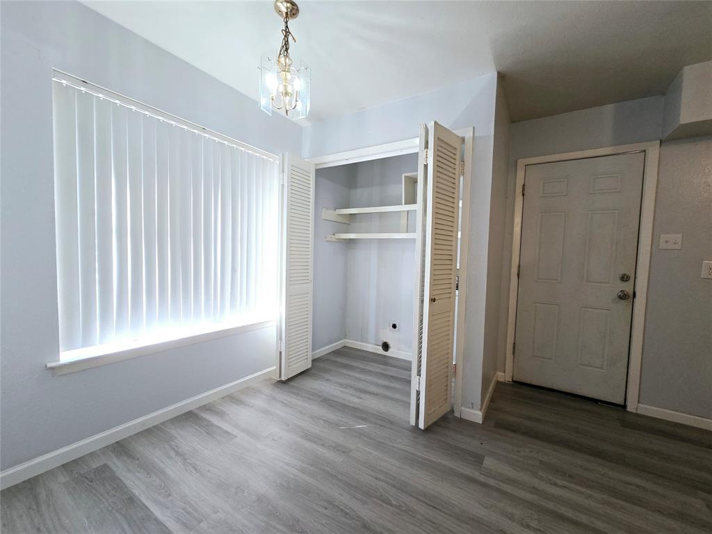 902 Spring Valley Plaza, Unit A Richardson, TX 75080 - Photo 5 of 11 an empty room with wooden floor cabinet and windows