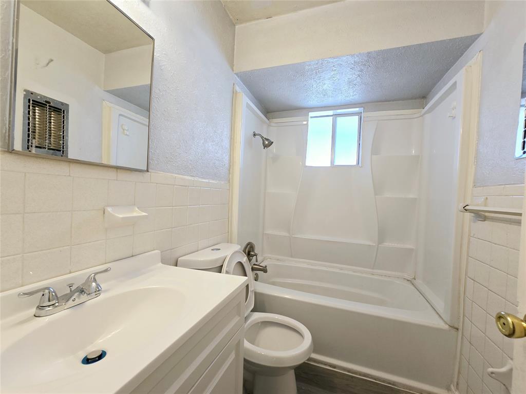 902 Spring Valley Plaza, Unit A Richardson, TX 75080 - Photo 10 of 11 a bathroom with a sink a toilet and a bathtub